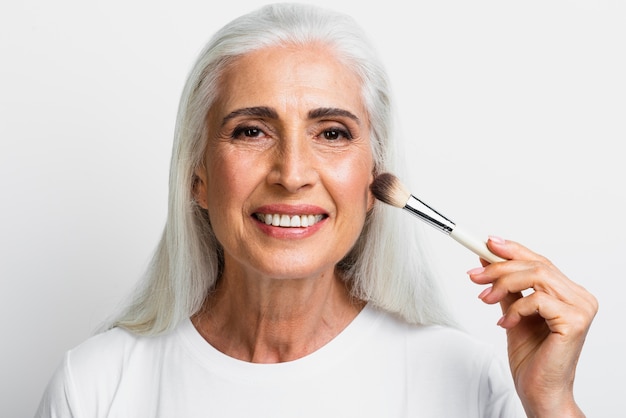 Photo gratuite portrait de femme avec pinceau de maquillage