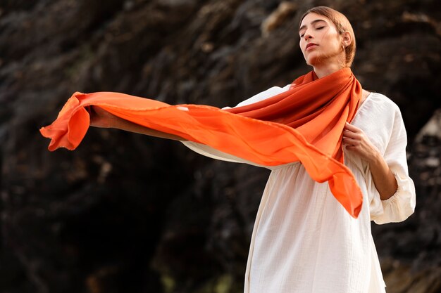 Portrait de femme à la plage couvrant son visage de voile