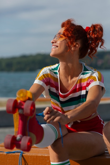 Photo gratuite portrait de femme à la plage avec des patins à roulettes dans l'esthétique des années 80