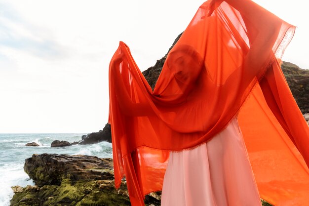 Portrait de femme à la plage avec le visage couvert de voile