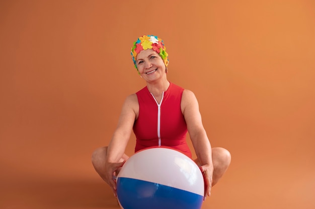 Portrait de femme plus âgée avec bonnet de bain floral et ballon