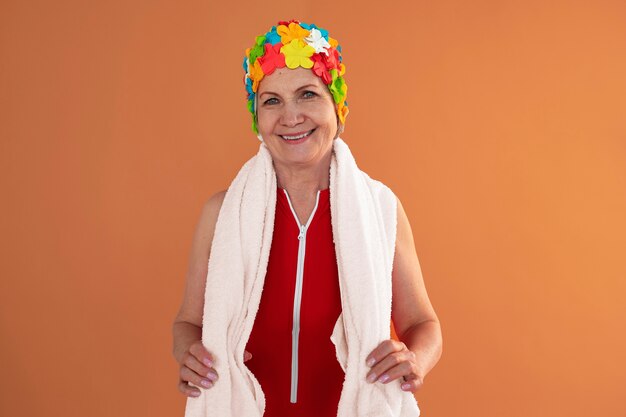 Portrait d'une femme plus âgée avec un bonnet de bain et une serviette à fleurs