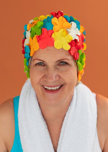 Portrait d'une femme plus âgée avec un bonnet de bain et une serviette à fleurs