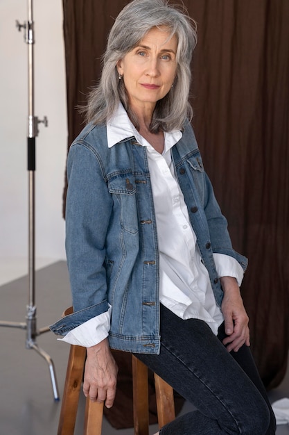Photo gratuite portrait de femme plus âgée posant dans une veste en jean