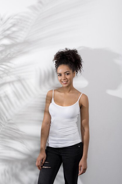 Portrait d'une femme portant un t-shirt blanc debout au mur