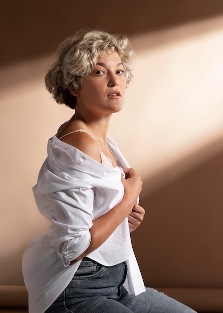 Portrait de femme posant en chemise blanche et montrant son soutien-gorge