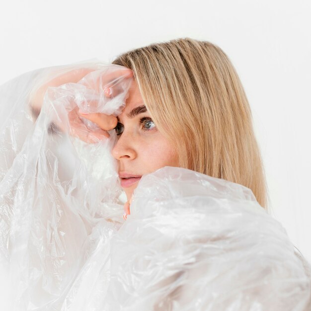 Portrait femme posant avec une feuille de plastique