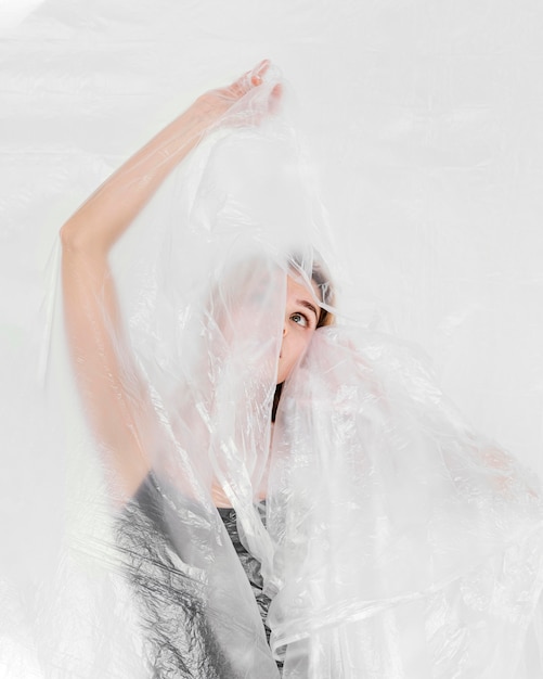 Portrait femme posant avec une feuille de plastique