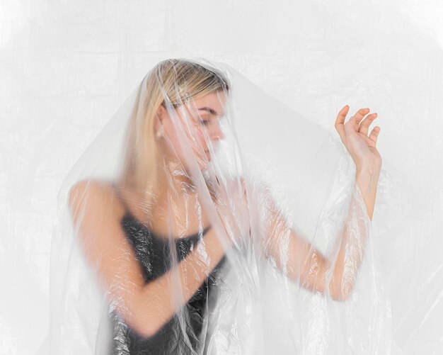 Portrait femme posant avec une feuille de plastique