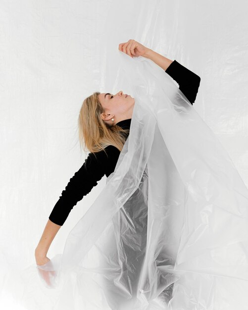 Portrait femme posant avec une feuille de plastique