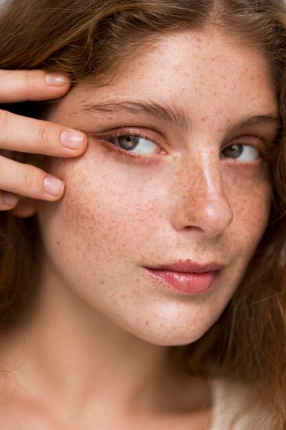 Portrait de femme posant de manière artistique avec sa main sur son visage