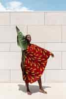 Photo gratuite portrait de femme posant en tenue africaine traditionnelle à l'extérieur