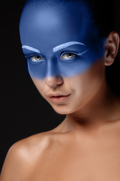 Portrait d'une femme qui pose recouverte de peinture bleue