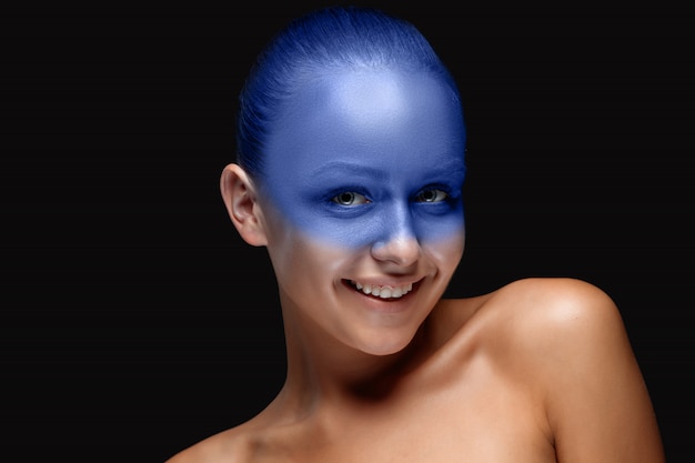 Portrait d'une femme recouverte de maquillage artistique bleu