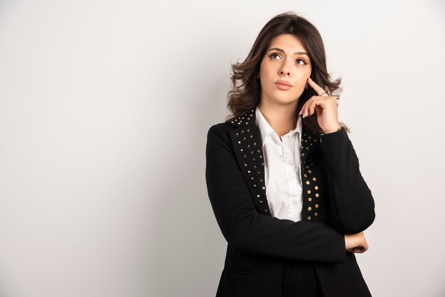 Portrait de femme réfléchie posant sur blanc