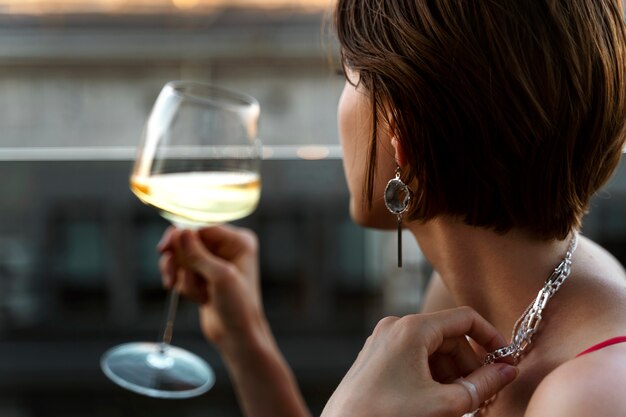 Portrait de femme riche buvant du vin à l'extérieur