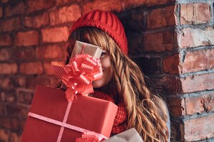 Photo gratuite portrait de femme rousse dans des vêtements chauds détient un cadeau de noël.