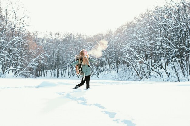 Portrait femme avec sac à dos le jour de l'hiver