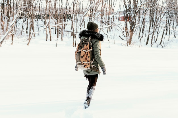 Portrait femme avec sac à dos le jour de l'hiver