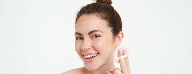 Photo gratuite portrait d'une femme se lavant le visage, enlevant son maquillage avec un tampon cosmétique et appliquant un nettoyant pour la peau