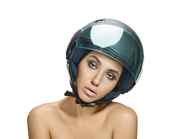 Portrait de femme séduisante en casque de moto sur mur blanc studio