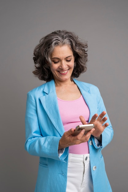 Portrait de femme senior élégante tenant son téléphone