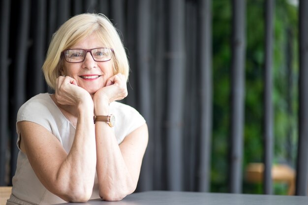 Portrait d&#39;une femme senior heureuse allongée sur les bras