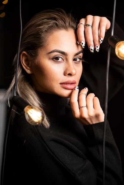 Portrait de femme sérieuse en pull noir debout et posant