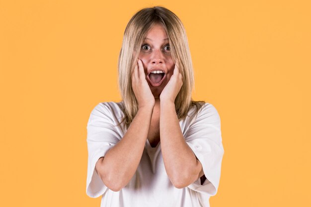 Portrait de femme sourde surprise devant fond coloré