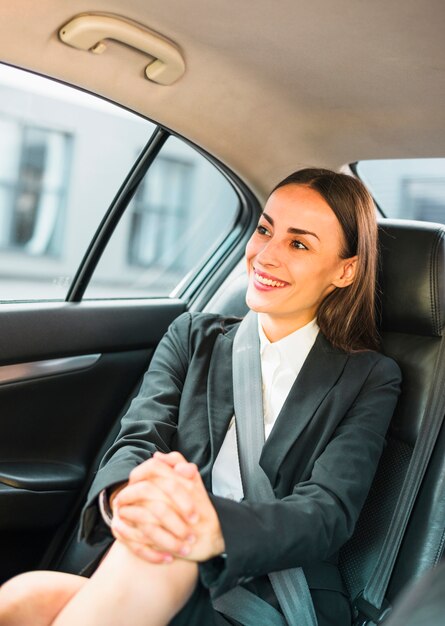 Portrait d&#39;une femme souriante assise à l&#39;intérieur d&#39;une voiture