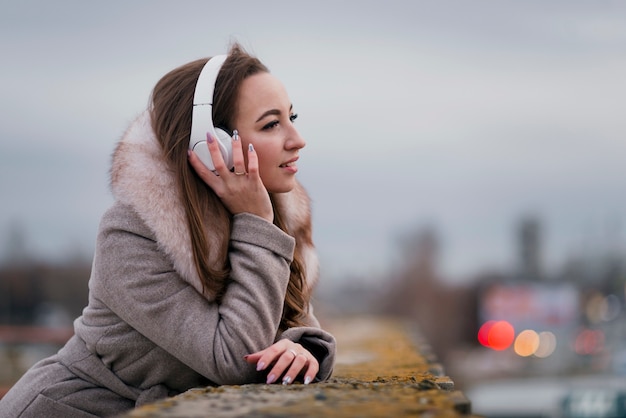 Photo gratuite portrait de femme souriante avec un casque sur le toit