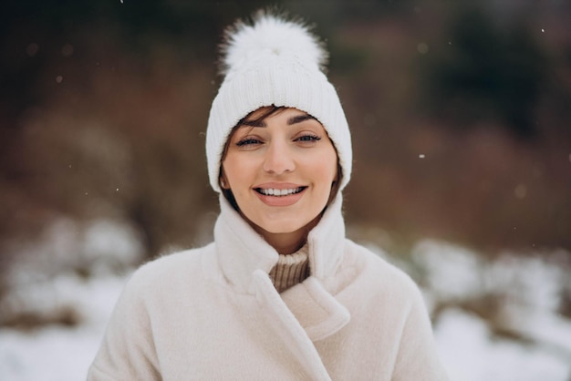 Portrait de femme souriante dans la forêt d'hiver