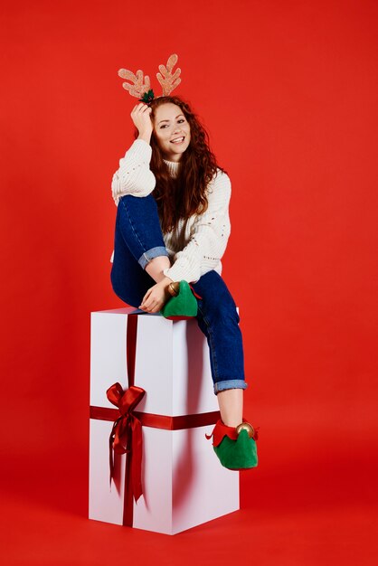 Portrait de femme souriante avec un énorme cadeau de Noël