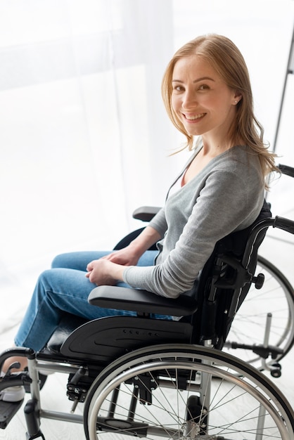 Portrait de femme souriante en fauteuil roulant