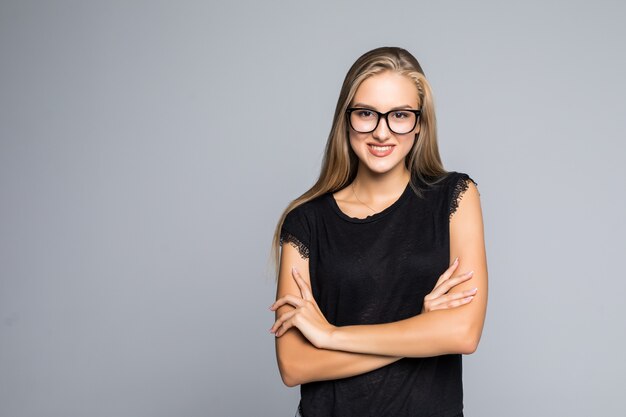 Portrait d'une femme souriante joyeuse en pull debout avec les bras croisés isolé sur fond gris