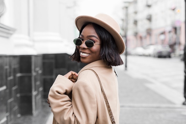 Portrait de femme souriante posant à l'extérieur