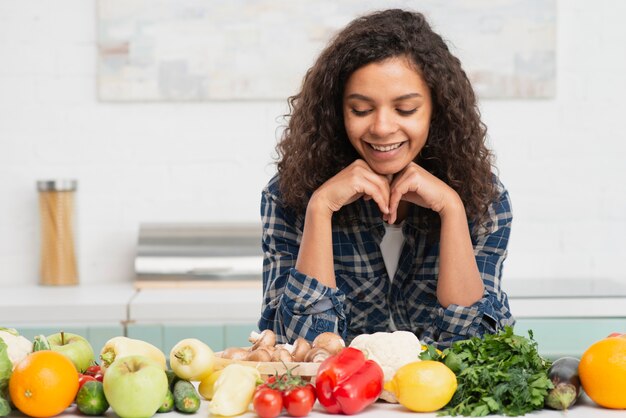 Portrait de femme souriante à la recherche de légumes