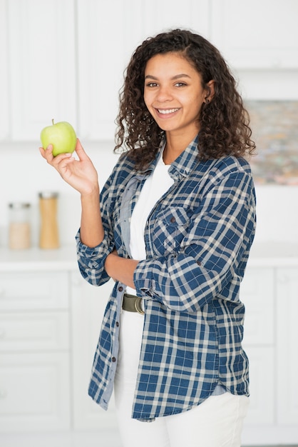 Photo gratuite portrait de femme souriante tenant une pomme