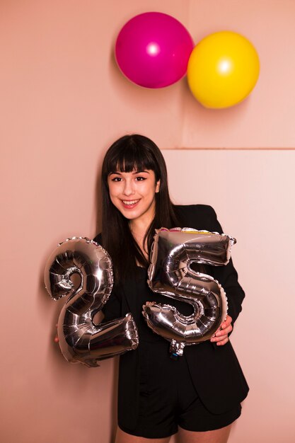 Portrait, de, a, femme souriante, tenue, 25, argent, célébration, balloon, dans, main