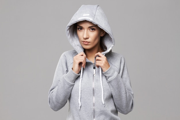 Photo gratuite portrait de femme sportive brutale à capuche et vêtements de sport sur blanc.