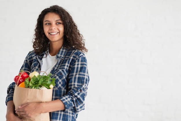 Portrait de femme tenant l'espace de copie de sac de légumes