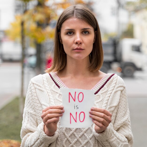 Portrait d'une femme tenant un panneau de sensibilisation