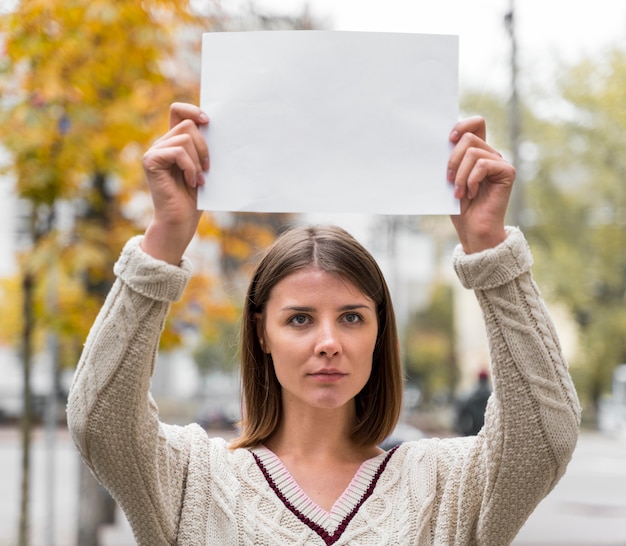 Photo gratuite portrait d'une femme tenant un papier vierge