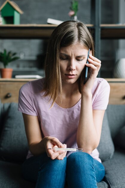 Portrait, femme, thermomètre, parler, téléphone portable