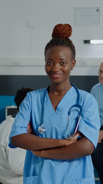 Photo gratuite portrait d'une femme travaillant comme infirmière en uniforme regardant la caméra dans l'armoire de la chambre d'hôpital. jeune assistant de santé adulte avec stéthoscope souriant à la clinique médicale du cabinet du médecin