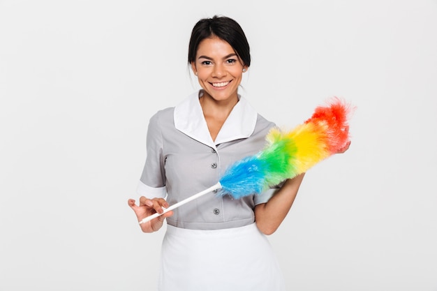 Portrait De Femme Très Souriante En Uniforme Tenant Un Nettoyeur De Poussière Coloré