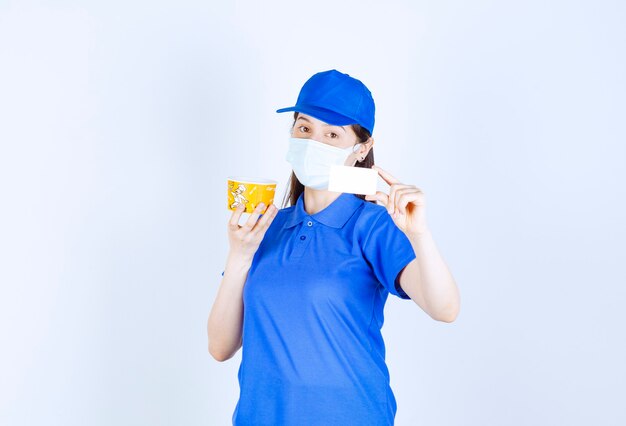 Portrait de femme en uniforme et masque médical holding card