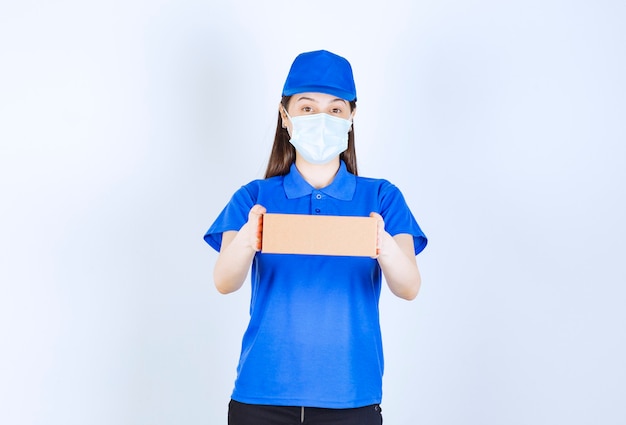 Portrait De Femme En Uniforme Et Masque Médical Tenant Une Boîte En Papier