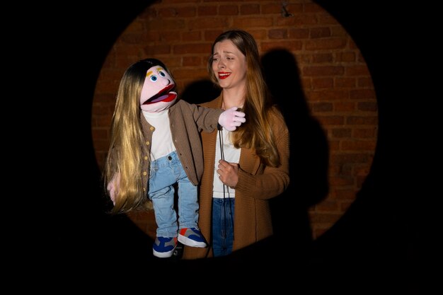 Portrait de femme ventriloque avec marionnette au spectacle