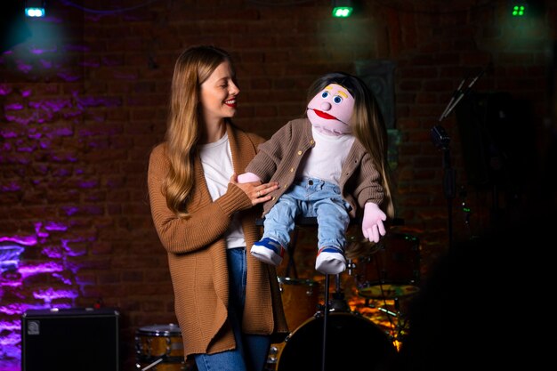 Portrait de femme ventriloque avec marionnette au spectacle